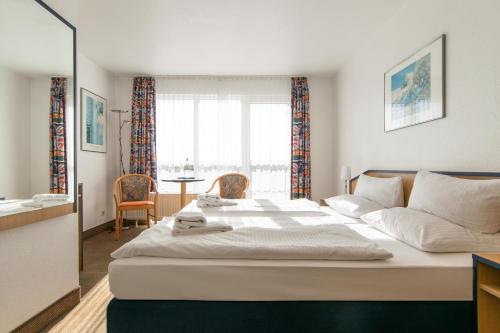 a bedroom with a large bed and a living room at Strandhotel Bansiner Hof in Bansin