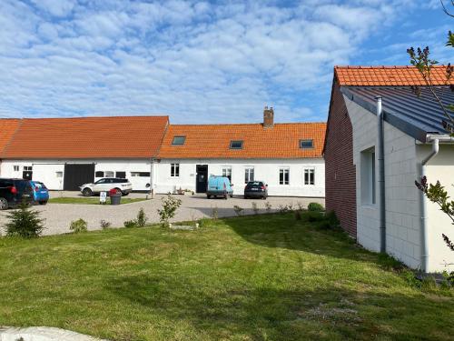 a group of buildings with cars parked in a parking lot at Le Refuge des Etoiles Gîte et Spa in Zutkerque