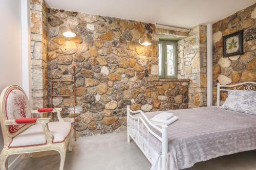 a bedroom with a bed and a stone wall at Casa Pietra in Kontokali