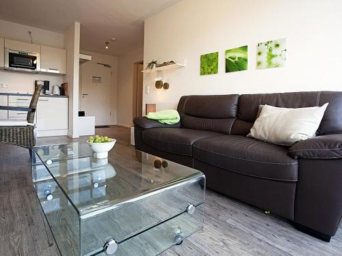 ein Wohnzimmer mit einem Sofa und einem Glastisch in der Unterkunft Residenz am Balmer See - BS 55 mit Wellnessbereich in Balm