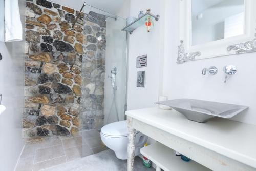 y baño con ducha de piedra y lavamanos. en Casa Pietra en Kontokali