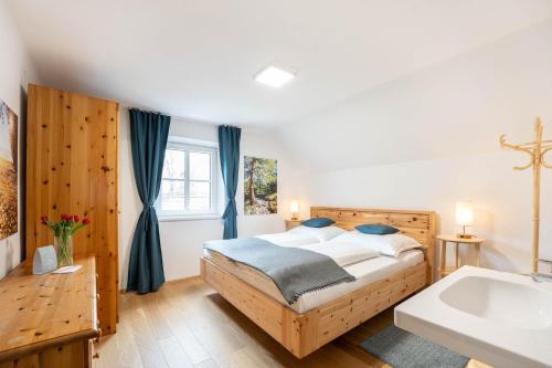 sypialnia z łóżkiem, umywalką i wanną w obiekcie Ferienhaus Zur alten Mühle w mieście Tamsweg