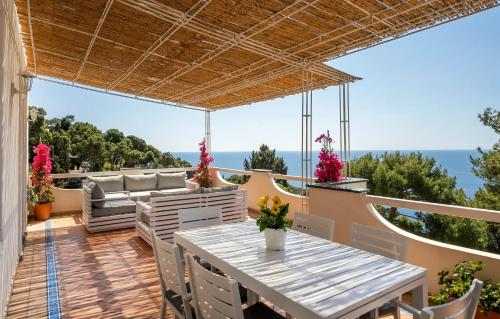 eine Terrasse mit einem Tisch und Stühlen sowie Meerblick in der Unterkunft Oliveto Capri apartments in Capri