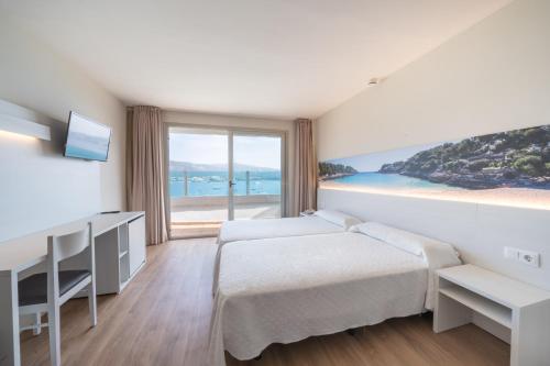 a hotel room with two beds and a large window at Seramar Hotel Comodoro Playa in Palmanova