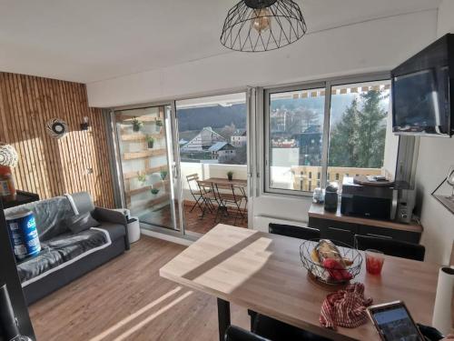 un salon avec une table et un canapé dans l'établissement appartement résidence val soleil., à Eaux-Bonnes