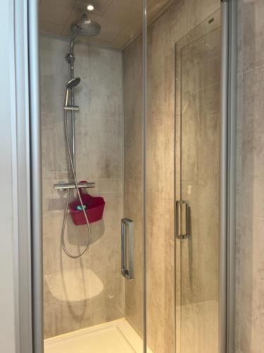 a shower with a glass door in a bathroom at MORI in Bruges