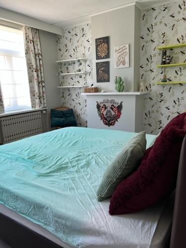 a bedroom with a bed with blue sheets and pillows at MORI in Bruges