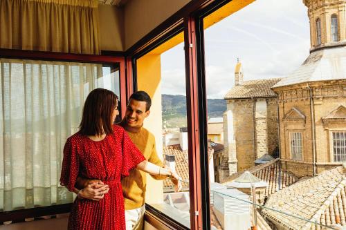 a man and a woman standing in front of a window at Maisonnave in Pamplona