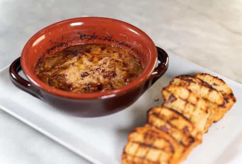 a plate with a bowl of soup and a piece of food at Agriturismo Podere La Rocca in Abbadia di Montepulciano
