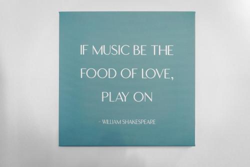a sign that says if music be the food of love play on at Emerald Stays UK at The Adelphi in Stratford-upon-Avon