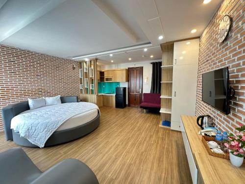 a bedroom with a bed and a brick wall at The Land Hotel & Apartment in Vung Tau