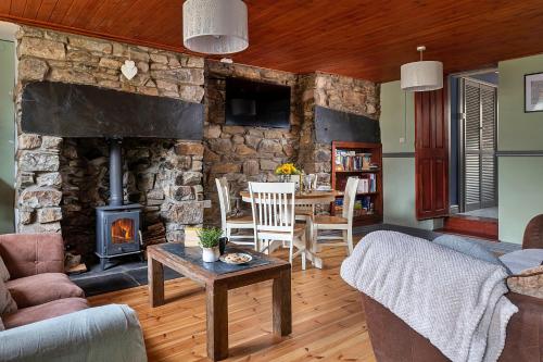 a living room with a stone wall with a fireplace at Finest Retreats - Maes Neuadd in Blaenau-Ffestiniog