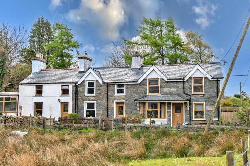 a large stone house in the middle of a field at Finest Retreats - Maes Neuadd in Blaenau-Ffestiniog