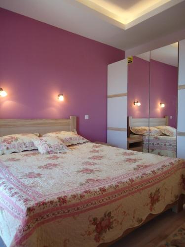 a bedroom with a large bed with purple walls at Villa Soleada in Herceg-Novi