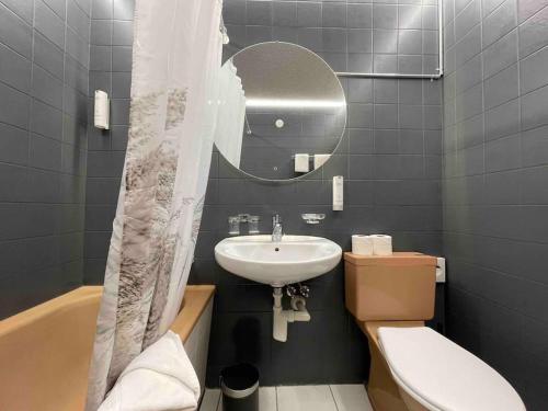 a bathroom with a sink and a toilet and a mirror at No.8 Boutique Apartment in Unterseen