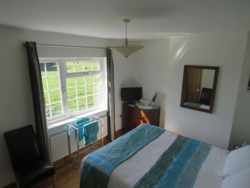 a bedroom with a bed and a window and a mirror at Bainvalley Cottages peaceful South Cottage in Lincolnshire