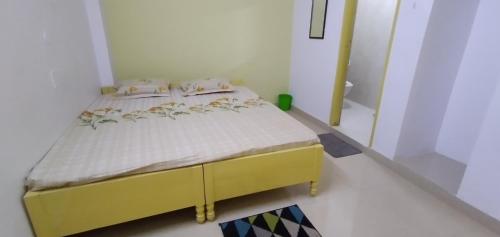 Un pequeño dormitorio con una cama amarilla en una habitación en Bimala Hotel, en Ranchi