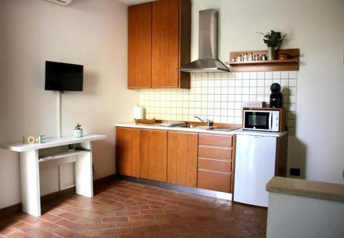 a kitchen with wooden cabinets and a white refrigerator at Casa Desi in Baura