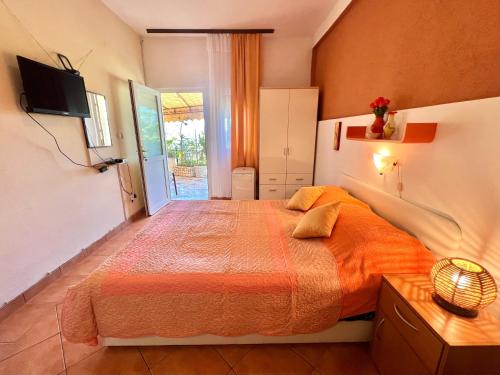 een slaapkamer met een bed met een oranje sprei bij Apartmani Zeleni Raj in Dramalj