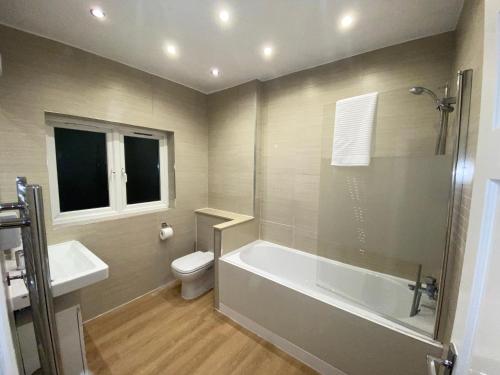 łazienka z wanną, toaletą i umywalką w obiekcie Beautiful large 6 bedroom house up to 14 people w mieście Hendon