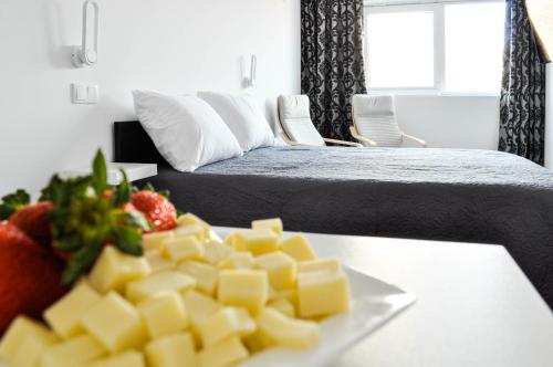 a plate of cheese on a table next to a bed at Cozy Seaside Studio Apartment C - Faraway in Lagoa