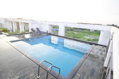 a swimming pool with blue water in a building at The Xen Suites, Kolkata Airport in Kolkata