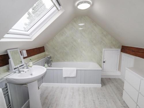a bathroom with a sink and a bath tub at Lee House Cottage in Cheddleton