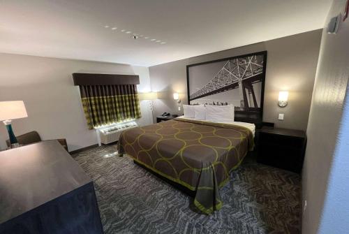 a hotel room with a large bed in a room at Super 8 by Wyndham Lake Charles/Sulphur in Lake Charles