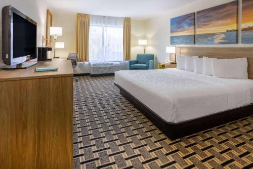um quarto de hotel com uma cama e uma televisão de ecrã plano em Hotel Carolina A Days Inn by Wyndham em Hilton Head Island