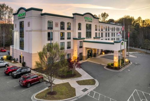 an aerial view of a hotel with cars parked in a parking lot at Wingate by Wyndham State Arena Raleigh/Cary Hotel in Raleigh