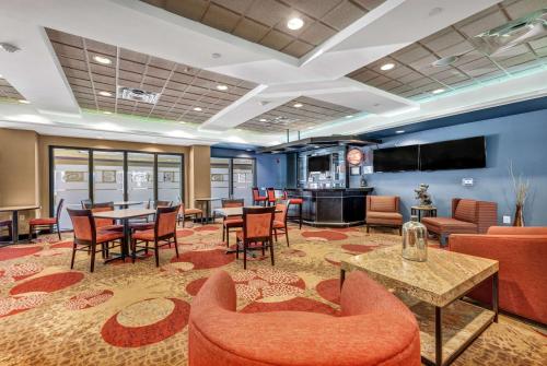 a lobby with tables and chairs and a bar at Wingate by Wyndham State Arena Raleigh/Cary Hotel in Raleigh