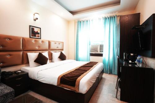a hotel room with a bed and a window at Hotel S & B East Inn - Patel Nagar in New Delhi