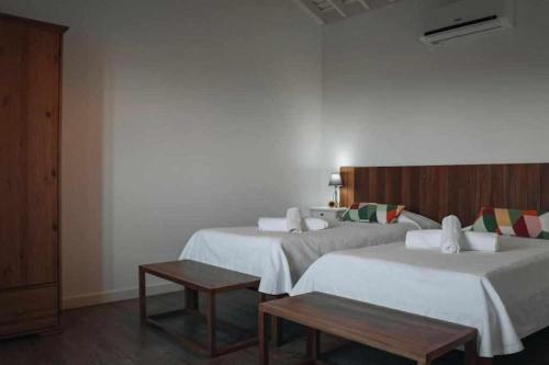 ノルデスチにあるCasas do Forneiro O Horizonte T2のベッド2台とテーブルが備わるホテルルームです。