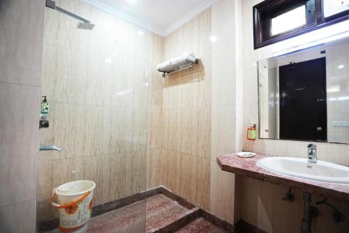 a bathroom with a sink and a toilet and a mirror at Hotel S & B East Inn - Patel Nagar in New Delhi