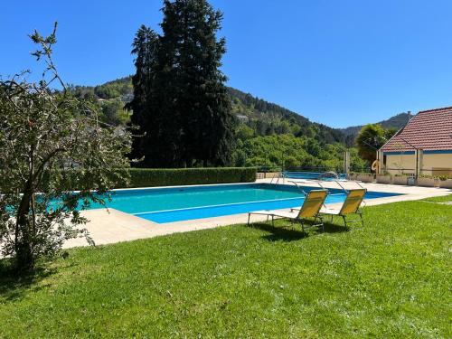 a swimming pool with two chairs in a yard at Morgado - River Suites and Houses by PCH in Padrões