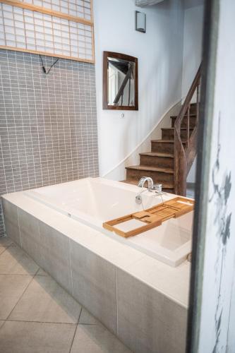 a bath tub in a bathroom with a staircase at Maison Harmonie in La Châtre