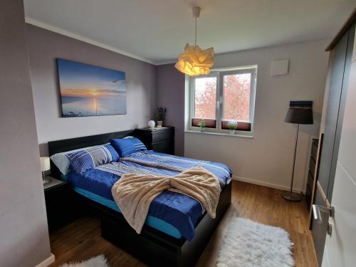 a bedroom with a bed with a blue comforter at Moderne Penthouse Wohnung in Schleswig