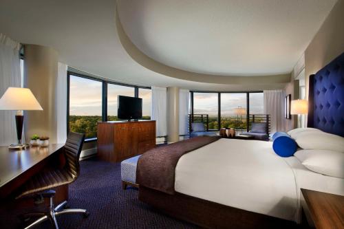 a hotel room with a large bed and a desk and chair at Hyatt Regency Lisle near Naperville in Lisle