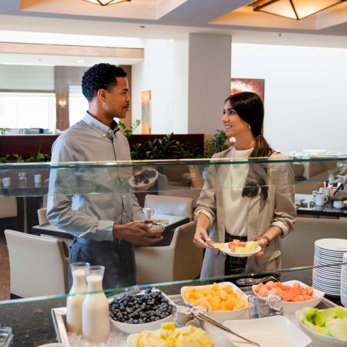 a man and woman standing in front of a buffet at Hyatt Regency Lisle near Naperville in Lisle