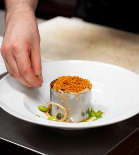 a person picking up a piece of food on a plate at Agriturismo Podere La Rocca in Abbadia di Montepulciano