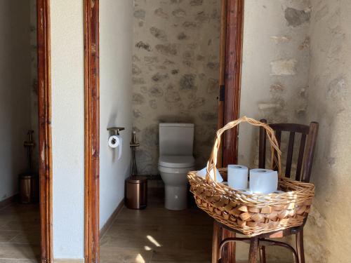 ein Bad mit einem WC und einem Korb mit Tassen in der Unterkunft Eco Maset in Ayelo de Malferit