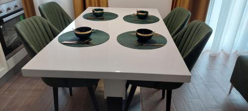 a white table with cups and saucers on it at Lux Apartmani Novi Park in Vrdnik