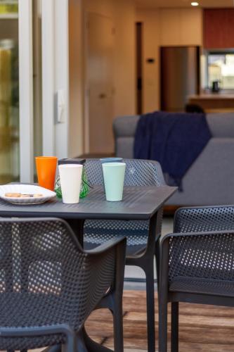 a table with four cups on top of it at City Lights Retreat with Carpark 2 Bed 2 Bath in Christchurch