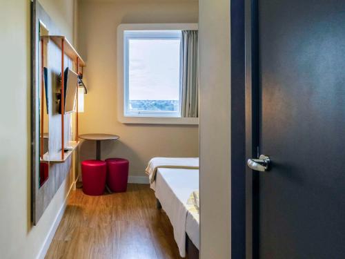 a small room with a bed and a window at ibis budget Foz do Iguaçu in Foz do Iguaçu