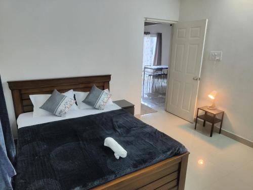 ein Schlafzimmer mit einem großen Bett mit einem weißen Objekt darauf in der Unterkunft NK Homes -Serviced Apartments - 2 BHK Homestay, Fast Wifi, Fully Furnished in Hyderabad