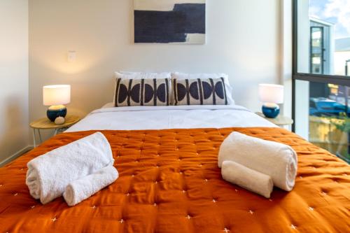 una camera da letto con un grande letto con due asciugamani di City Lights Retreat with Carpark 2 Bed 2 Bath a Christchurch