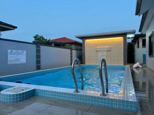 a swimming pool with two metal rails in a house at Pantai Dickson Stay 3838 with Private Pool in Port Dickson