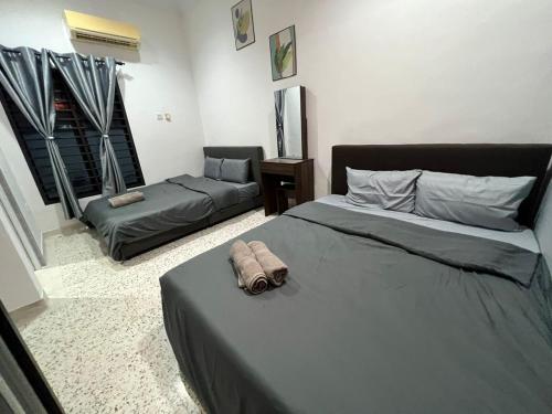 a bedroom with two beds and a bed and a couch at Pantai Dickson Stay 3838 with Private Pool in Port Dickson