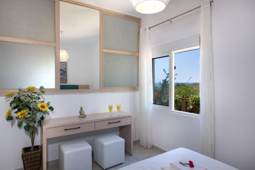 La salle de bains est pourvue d'un lavabo et d'un miroir. dans l'établissement Elafonisi Village, à Elafonisi