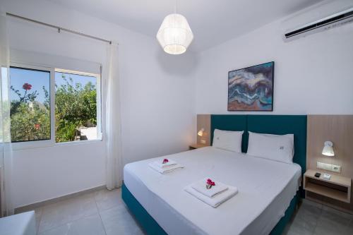a bedroom with a white bed with two white towels at Elafonisi Village in Elafonisi
